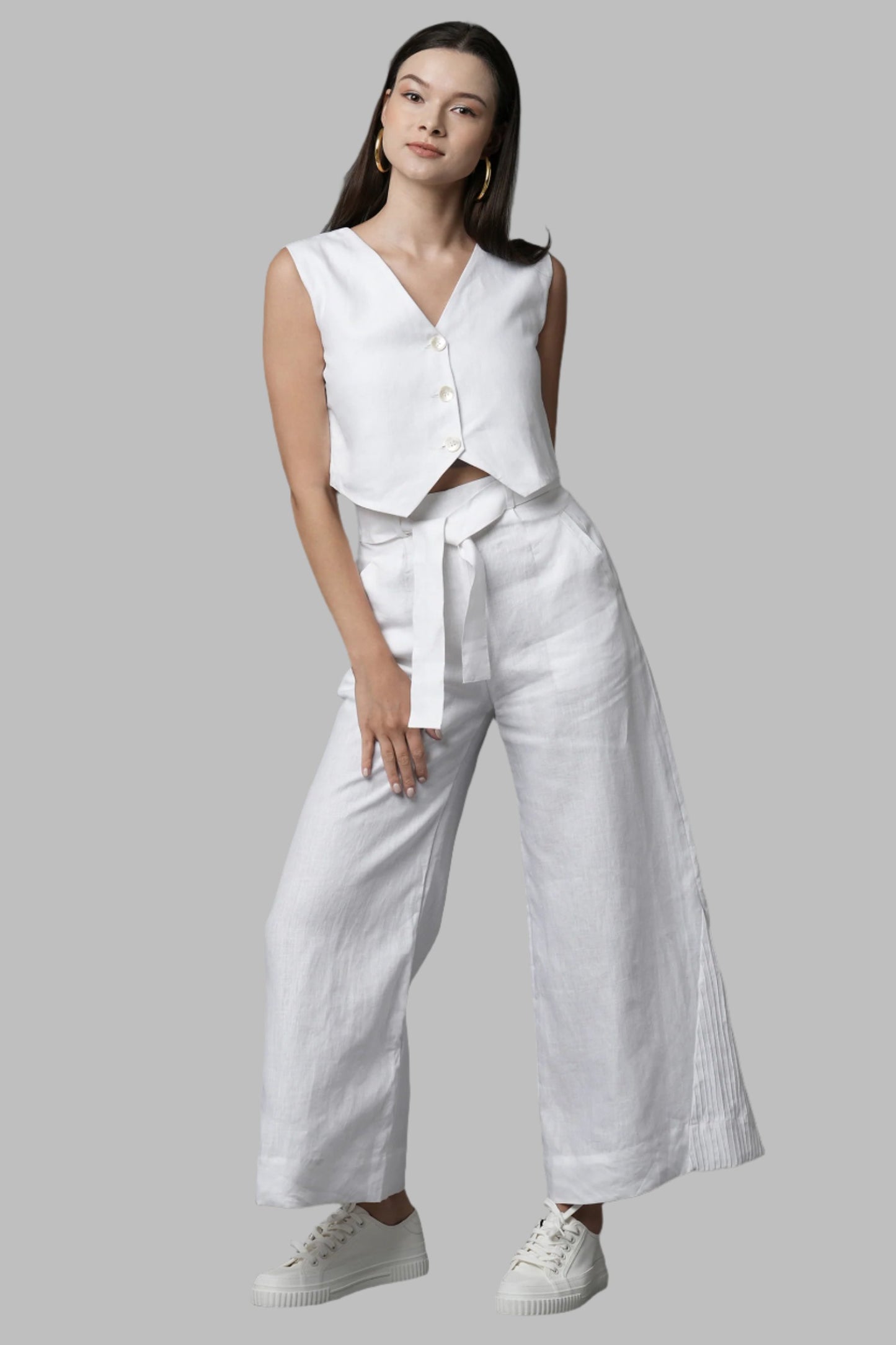 White Tranquil Pants for Women are crafted from 100% pure hemp, offering breathability and comfort. These sustainable culotte pants feature flowy and flared design with stitching and pin tuck details. Complete with a cloth belt, they allow for customization and adaptability. Embrace a conscious wardrobe and make a fashion statement with these exceptional pieces from B Label.